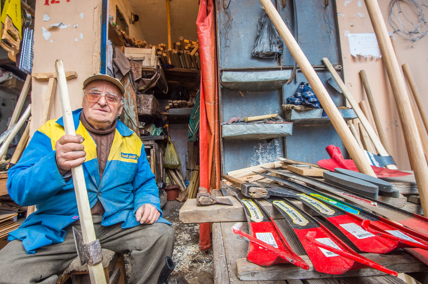 Een verkoper van zeisen en ander landbouwmateriaal. © Billy Herman