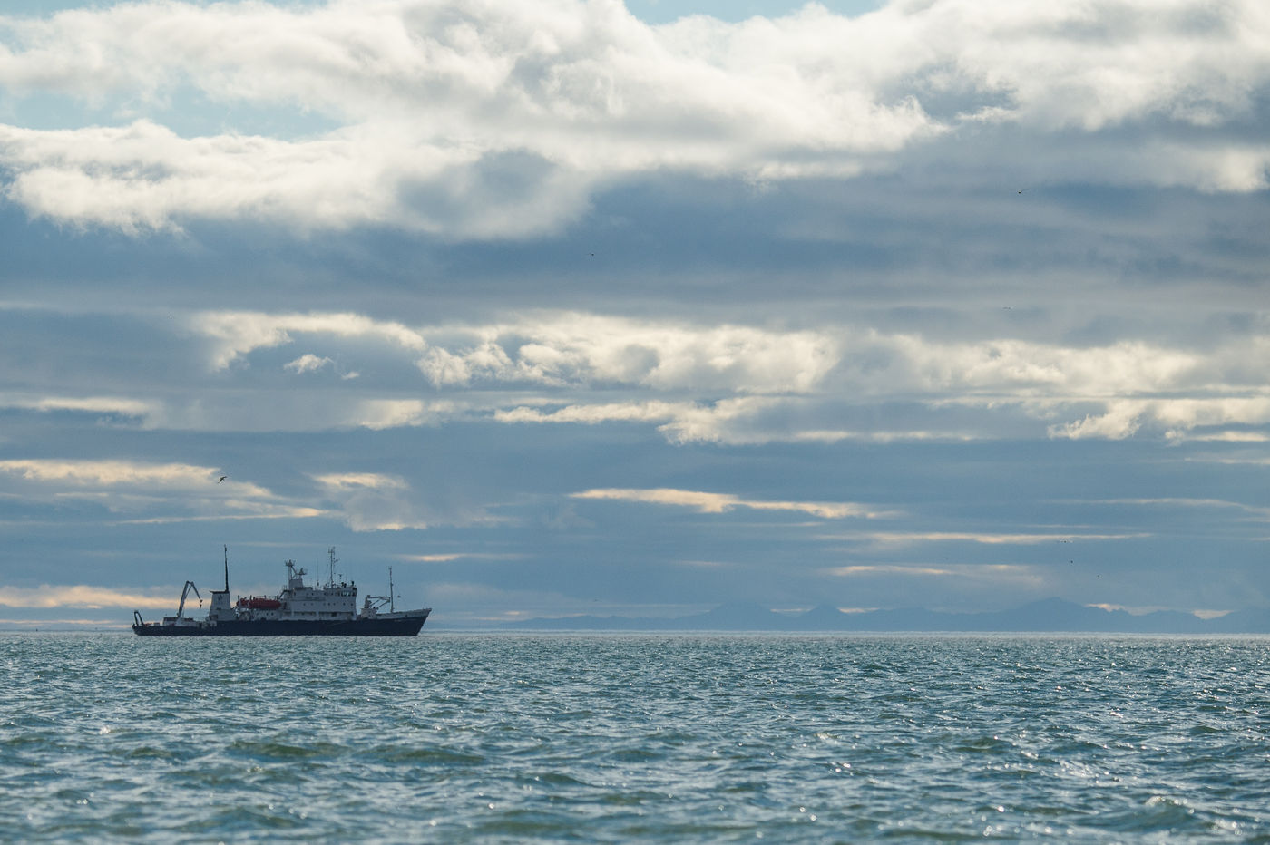 KamtchatkaBillyHerman (330 van 337) Het schip vaart langs, met de woeste Pacifische kust op de achtergrond. © Billy Herman