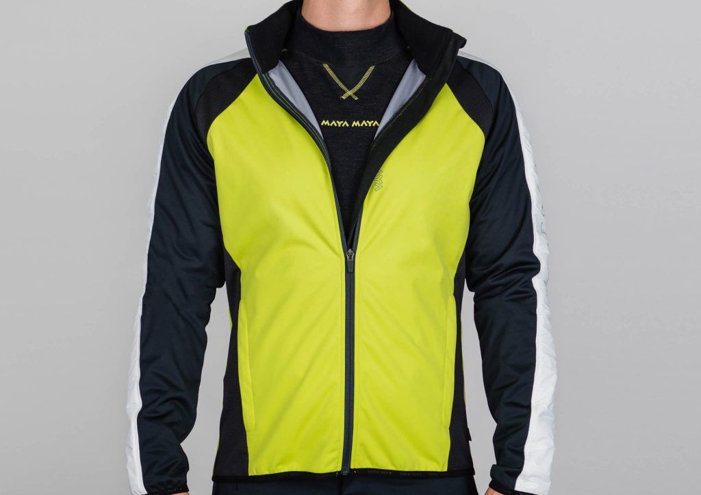 A man wearing an ultralight softshell men's jacket for chilly temperatures with reflective prints and stretch inserts.