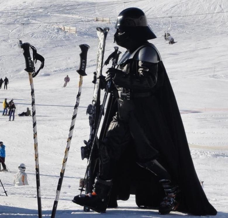 A man on the ski slopes dressed as Darth Vader.