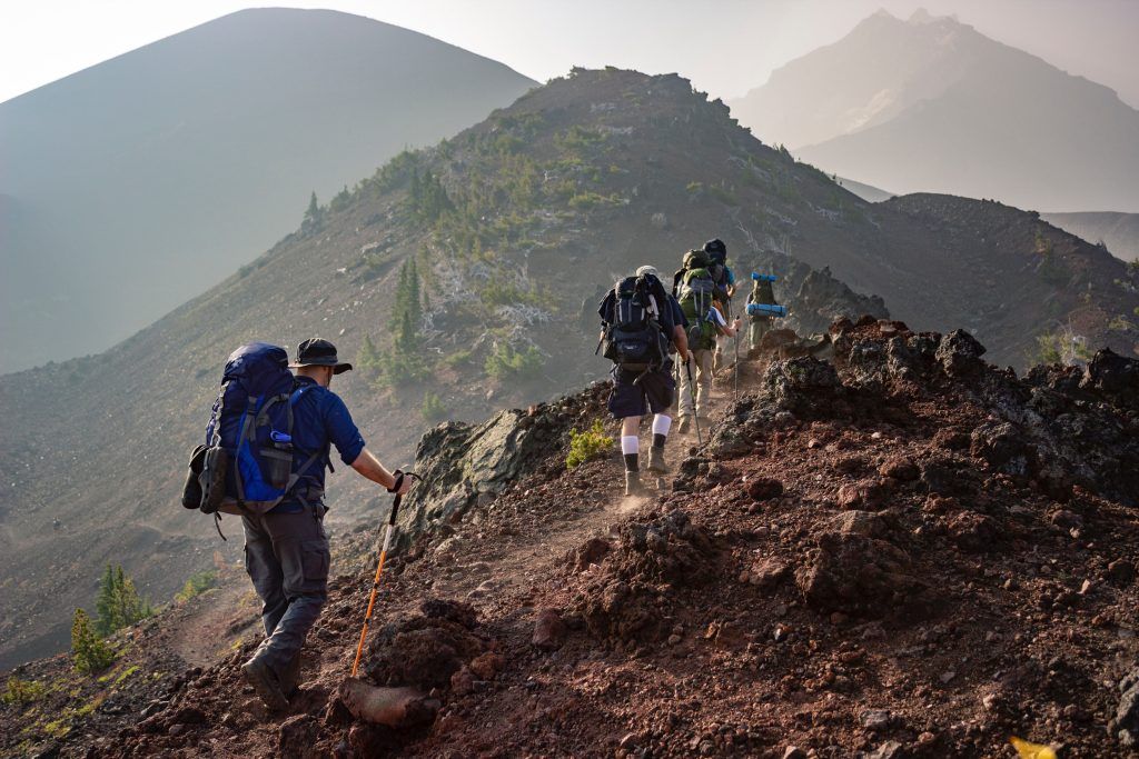 People trekking with lots of equipment on them