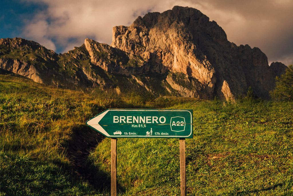 Road sign direction to Brenner in Italy with mountains in the background