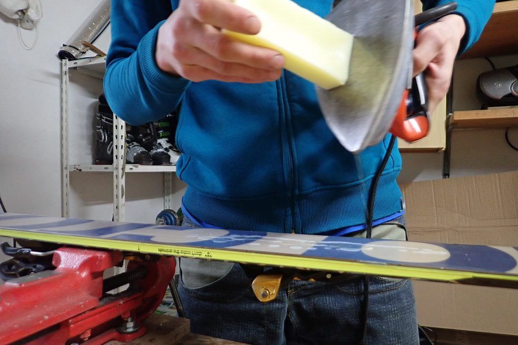 A man applying wax to the skis.