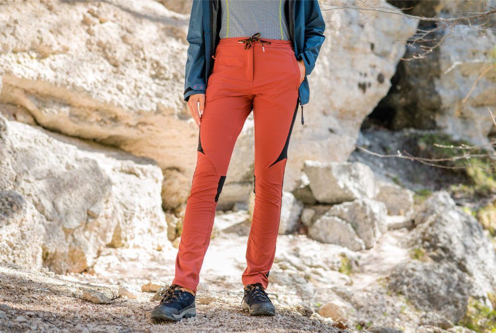 A woman wearing long red pants for outdoor activities.