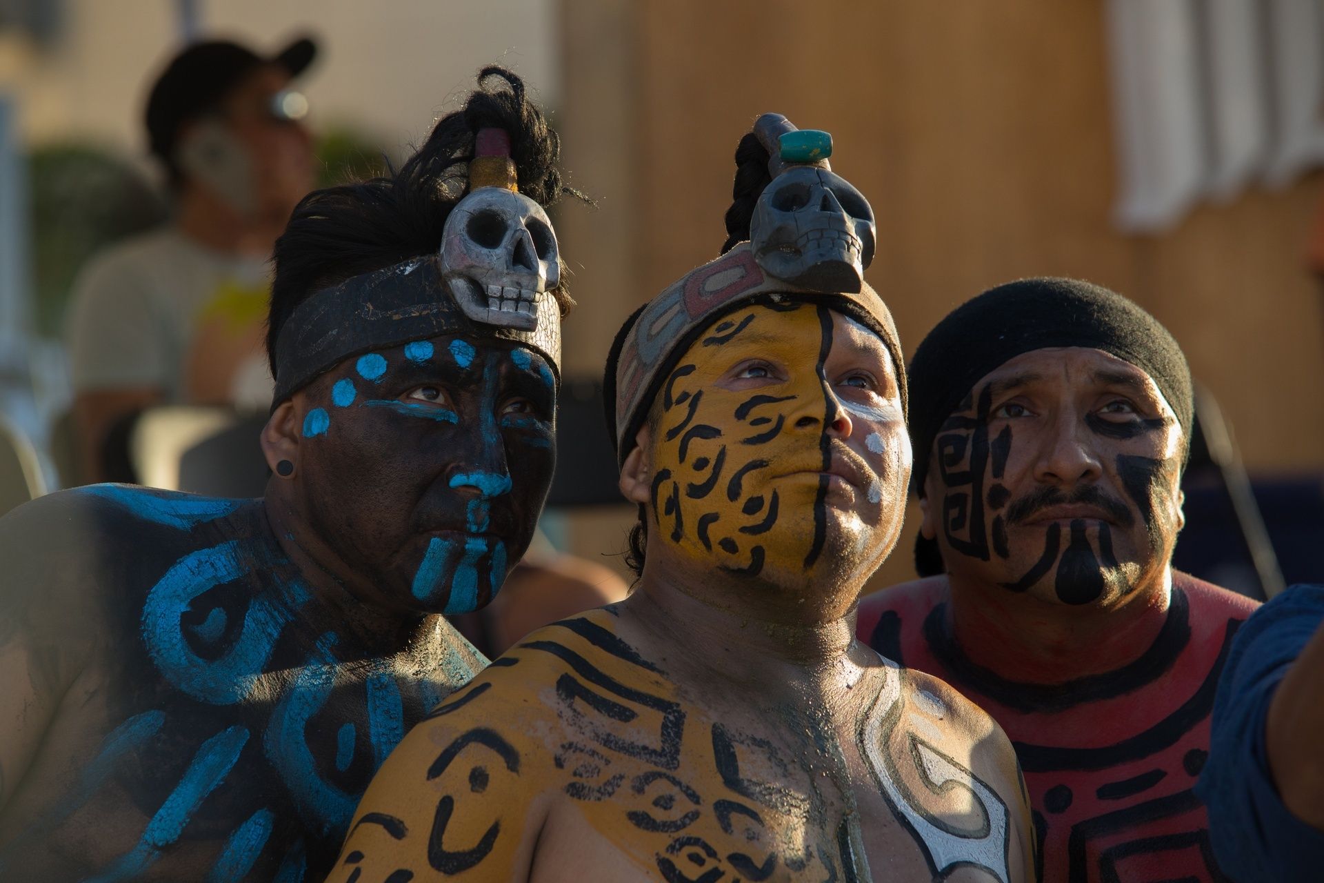 Men with traditional Mayan face paintings and accessories.