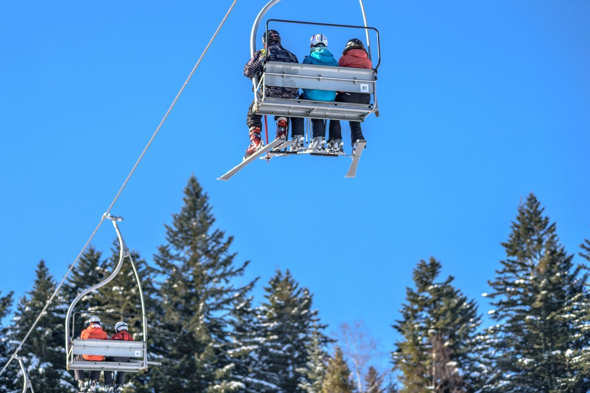 People with skis on a ski line.