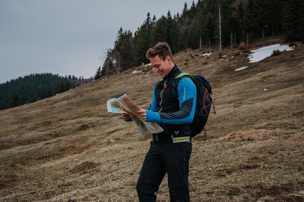 A man with a map hiking in the mountains.