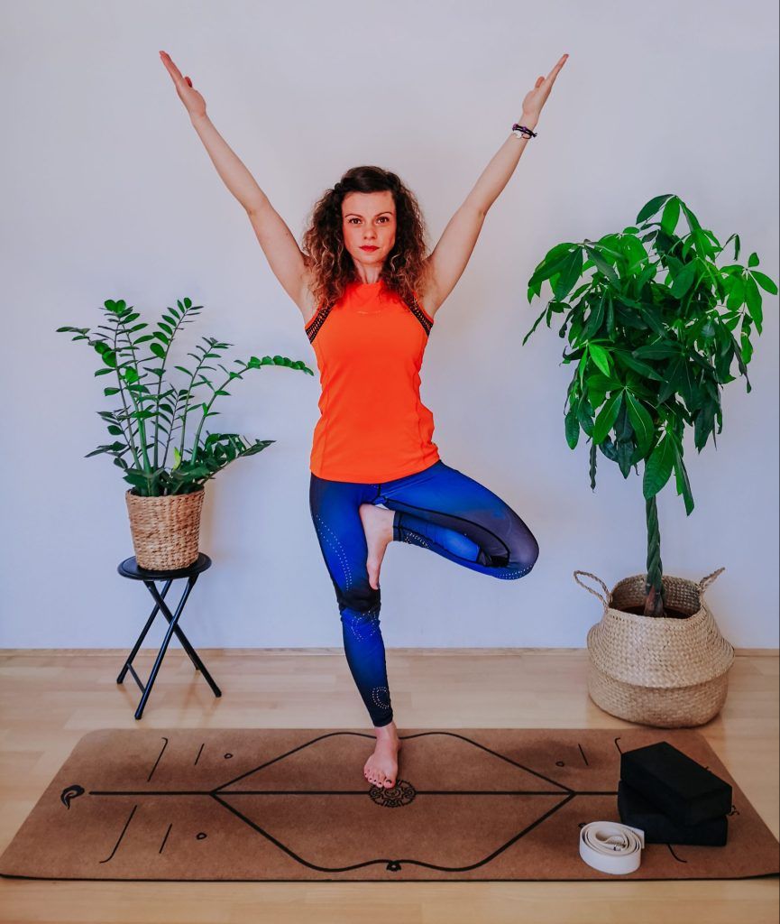 Woman doing tree pose on a yoga mat.