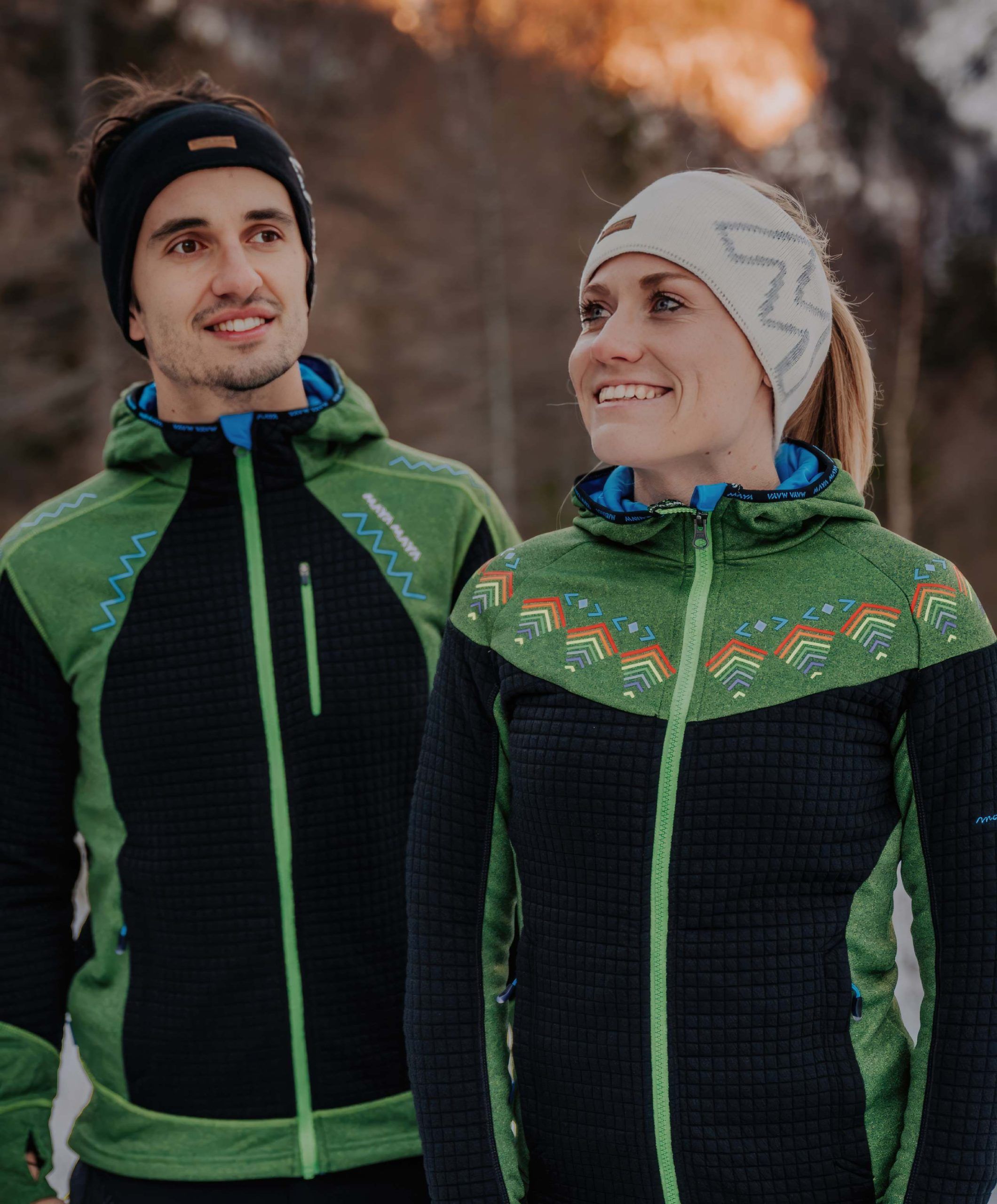 Man and women walking in the mountains wearing black and white winter headbands from MAYA MAYA