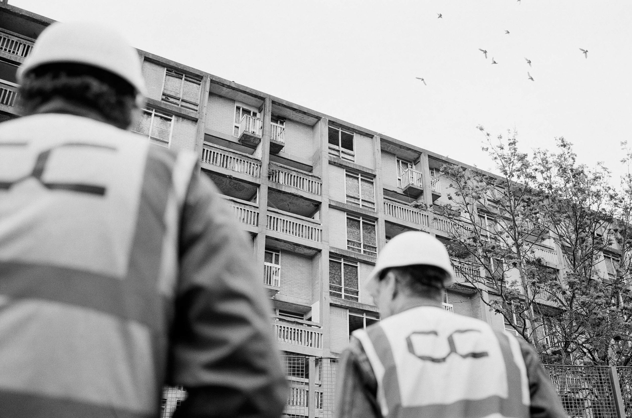 Two people on a tour wearing hard hats and hi-vis at Park Hill, Sheffield.