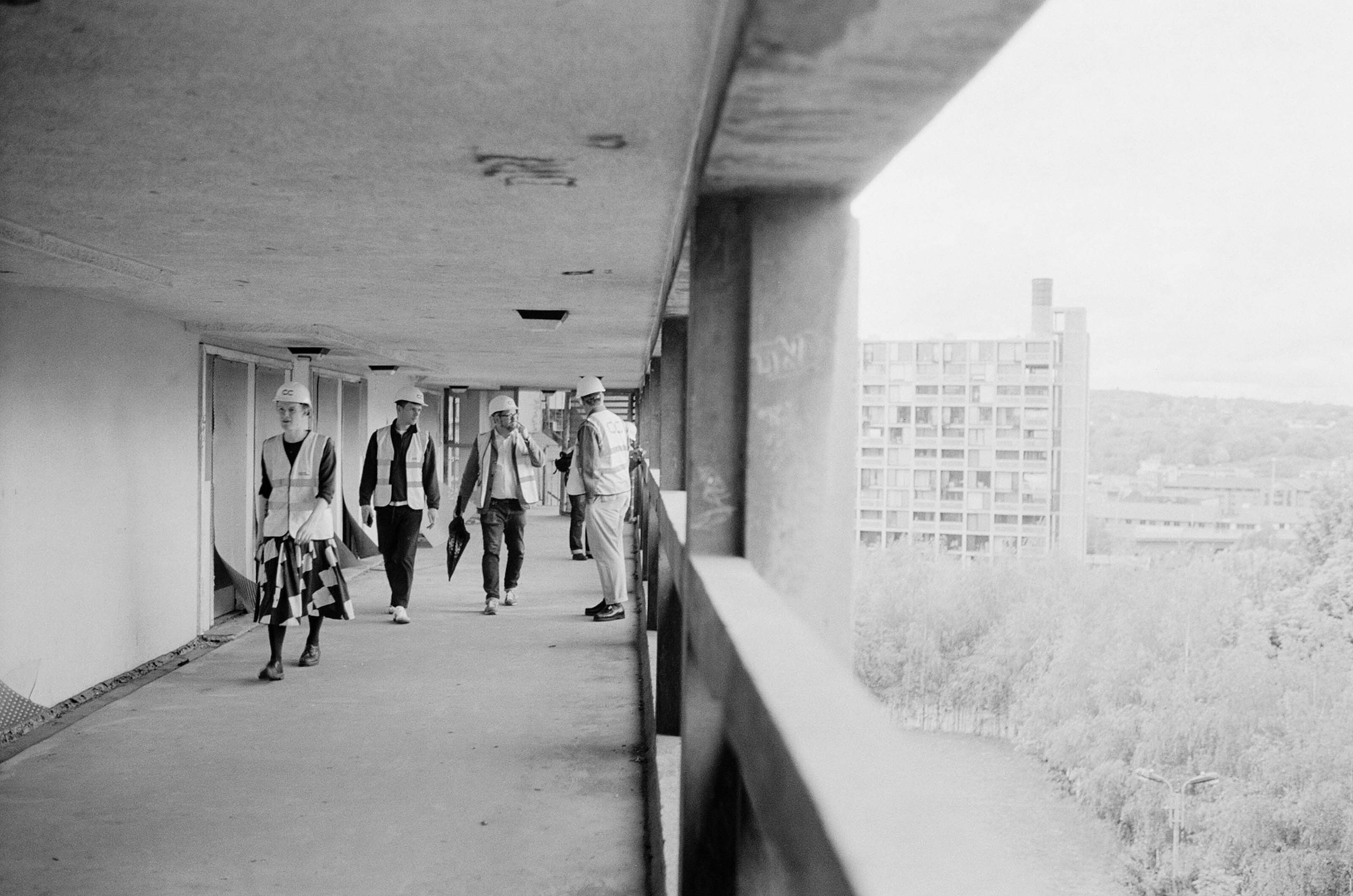 A group of people on a tour wearing hard hats and hi-vis at Park Hill, Sheffield.