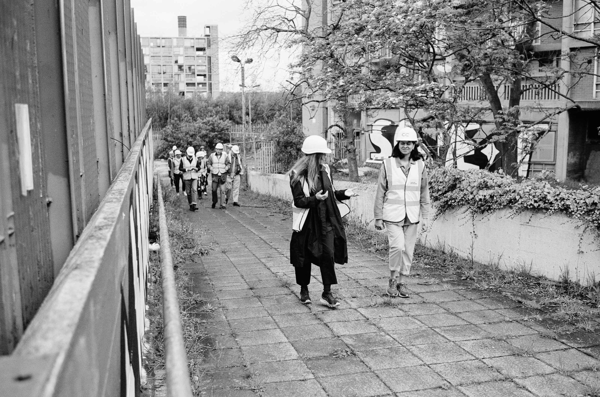 A group of people on a tour wearing hard hats and hi-vis at Park Hill, Sheffield.