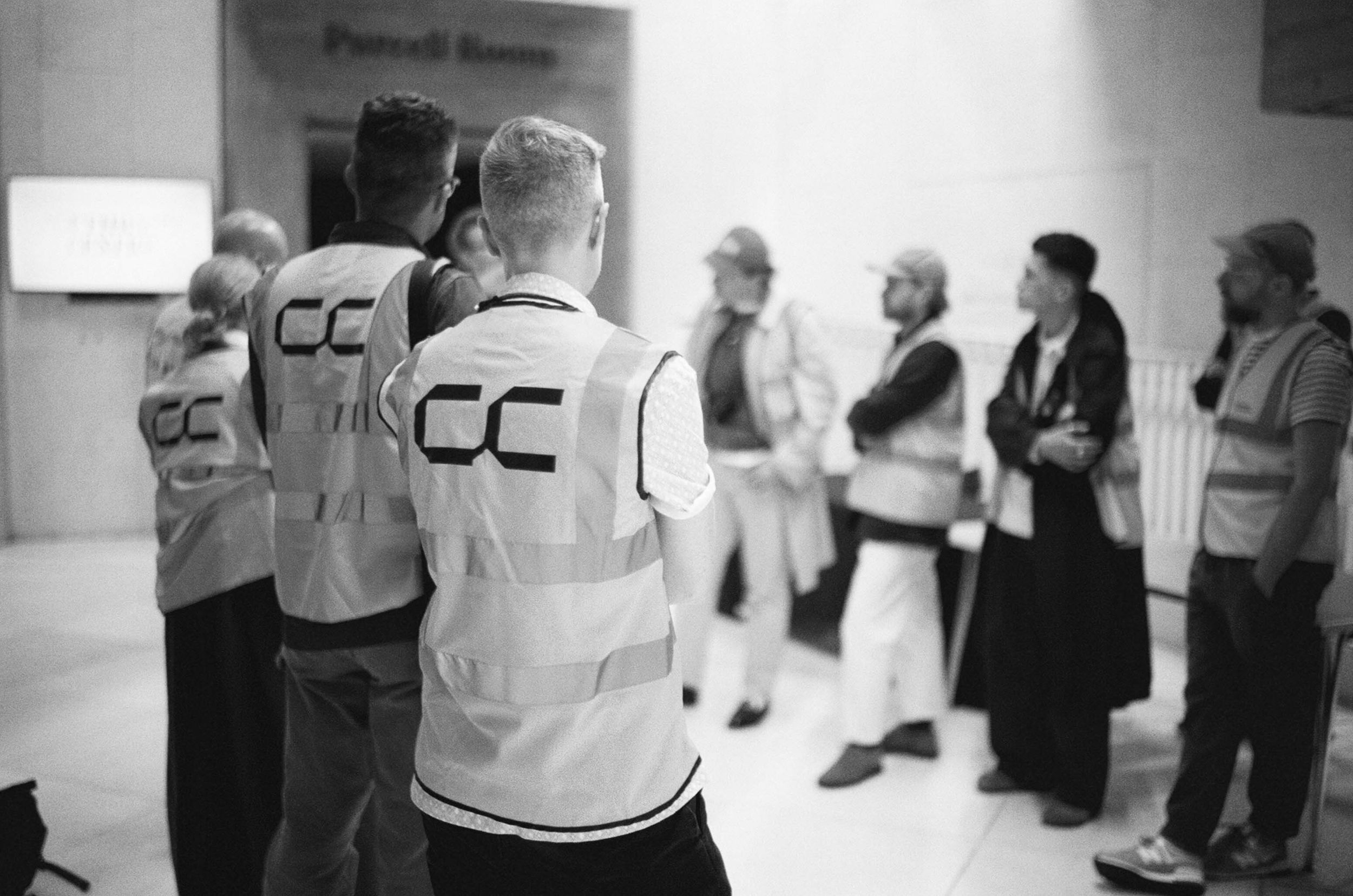 Shot from behind, a group of people wearing hi-vis with Concrete Communities logo printed on the back at the Southbank Centre, London.