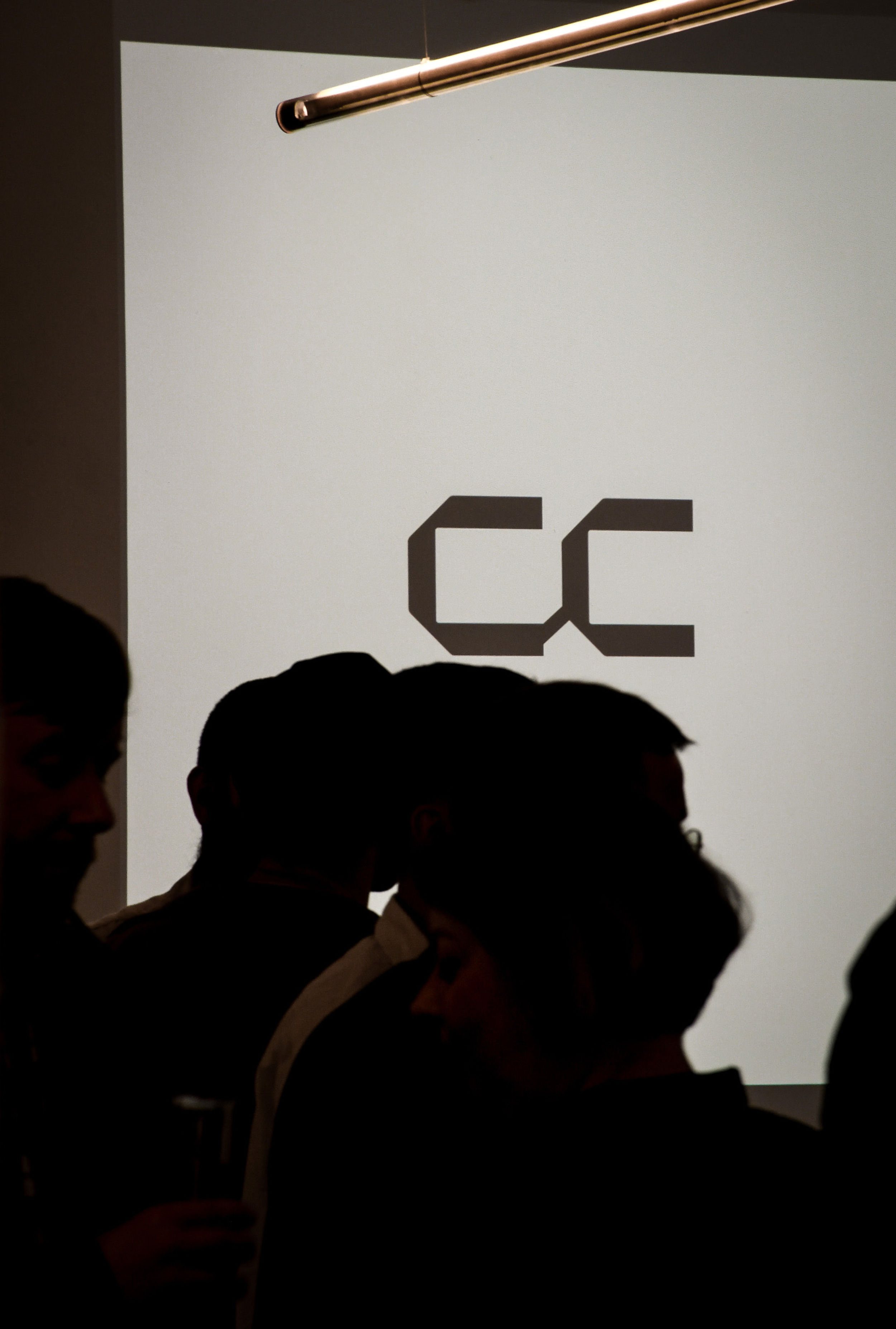 Silhouettes of people in front of a Concrete Communities projected logo.