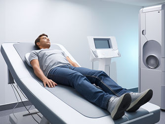 man waiting for a DEXA scanner to start