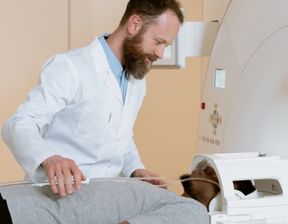 Doctor helping patient into MRI scacnner