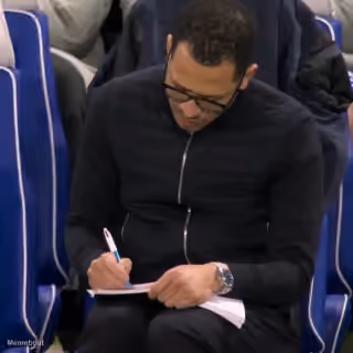 Liam Rosenior taking notes on the sideline during a match
