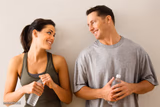 Man And Woman Smiling With Water Bottles