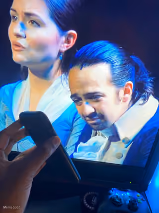 Man Holding Phone Watching Hamilton