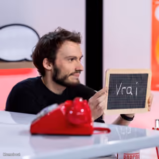 Man Holding 'Vrai' Sign