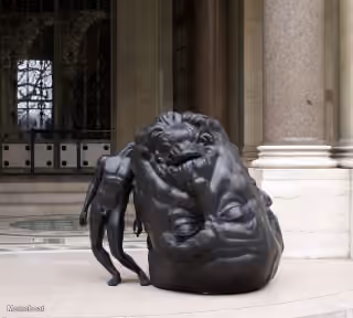 Man Leaning on Giant Head Statue