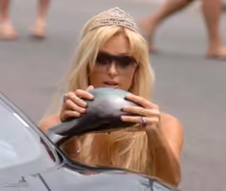 Paris Hilton adjusting her tiara in the rearview mirror