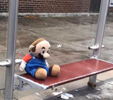 Plush Mario on bus stop