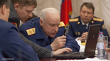 Russian general looking at laptop with magnifying glass