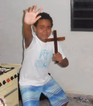 scared kid holding a cross