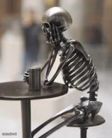 Still waiting skeleton at table with cup