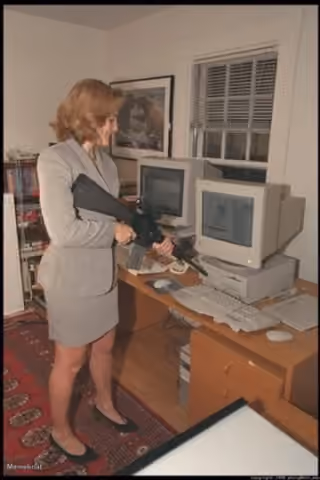 Woman Pointing a Gun at a Computer