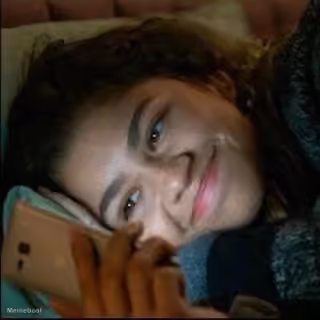 Zendaya smiling looking at phone - 'Euphoria'