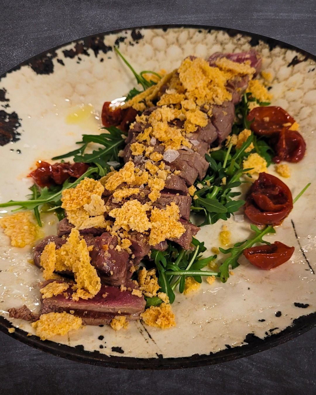 Tagliata Di Manzo Con Rucola, Pomodoro Ciliegino Sott'olio E Cialda Di Grana Croccante