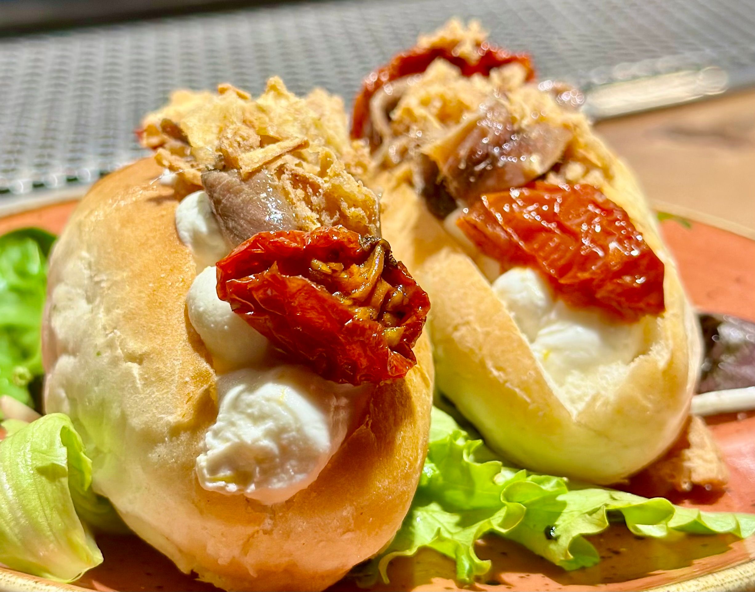 Maritozzi Salati Con Caprino Agrumato, Alici, Cipolla Croccante E Pomodoro Confit (2 Pz)