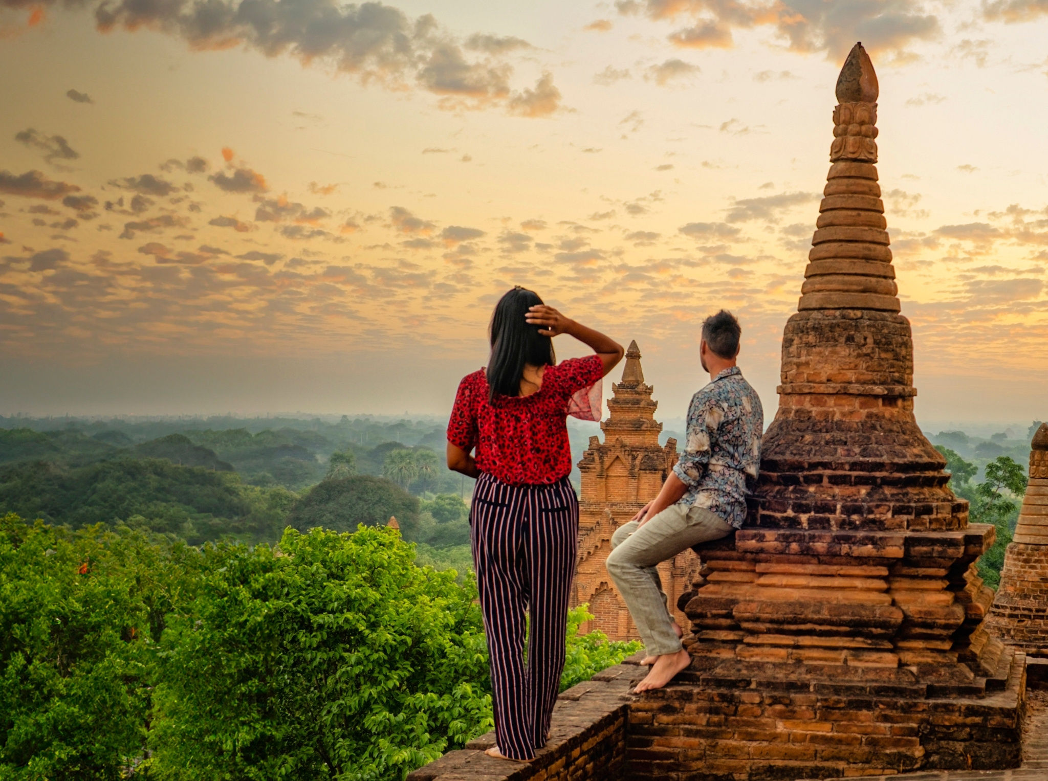 Two travelers exploring ancient temples at sunrise, embracing immersive and off-the-beaten-path experiences beyond typical tourist spots.