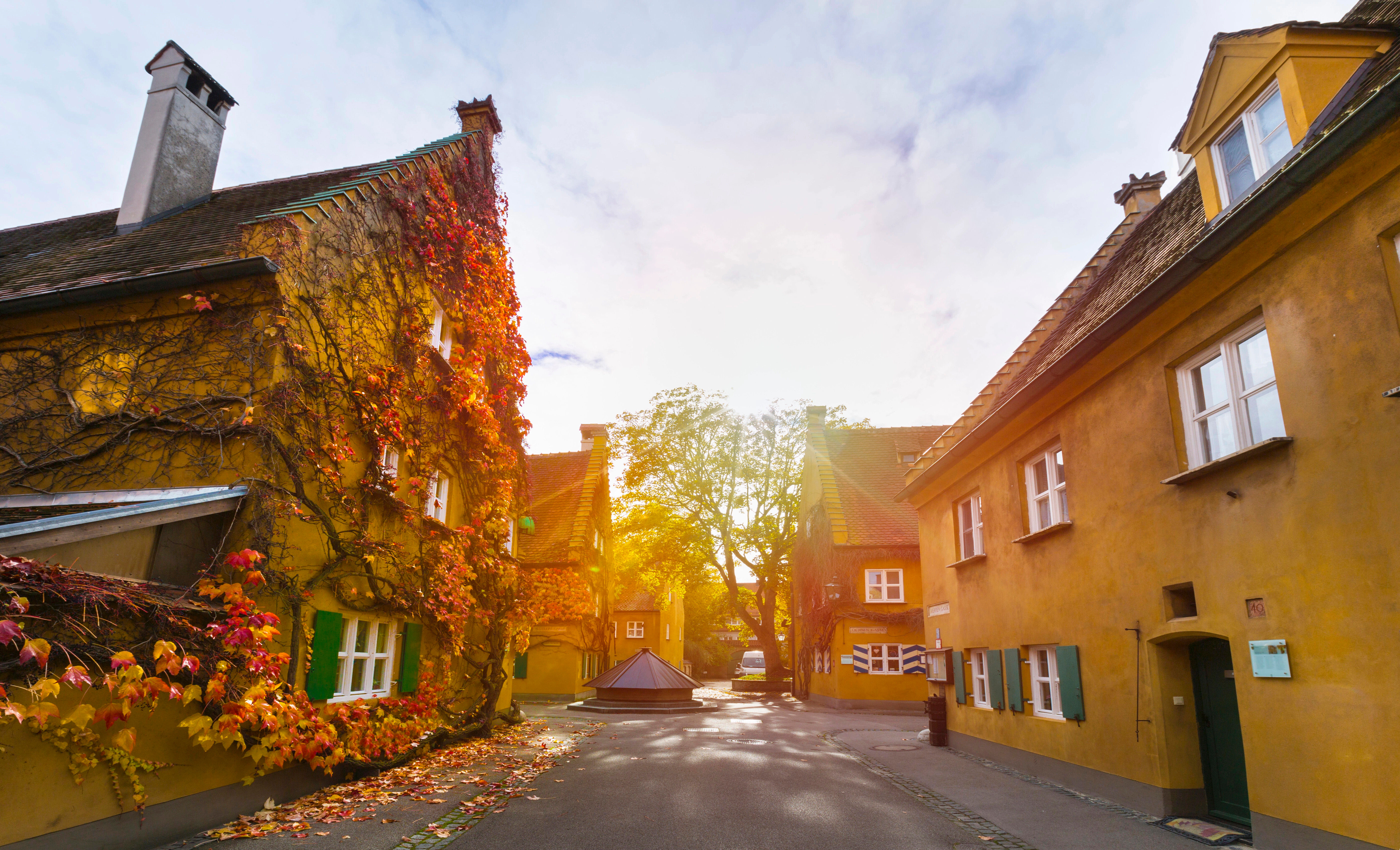 Golden-hued street in a quiet European village during early fall with soft lighting and no crowds.