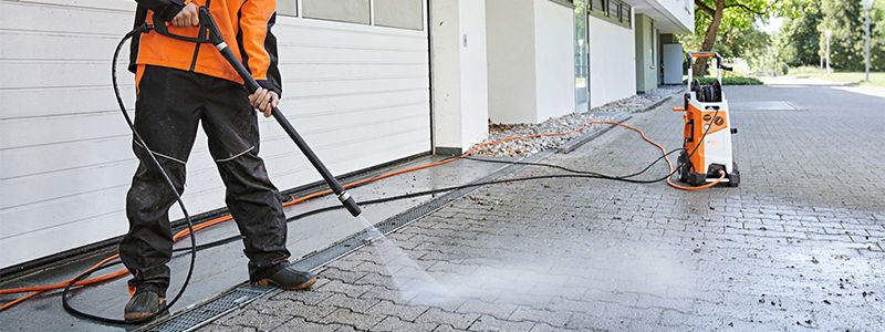 Man cleaning yard with rotary nozzle