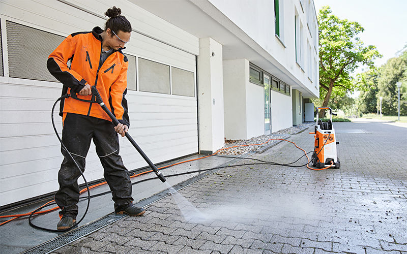 Man cleaning yard with rotary nozzle