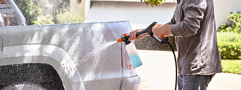 Man cleaning his car with Stihl pressure washer with foam nozzle