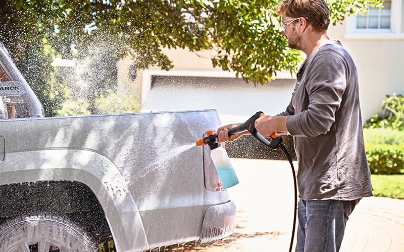 Man cleaning his car with Stihl pressure washer with foam nozzle