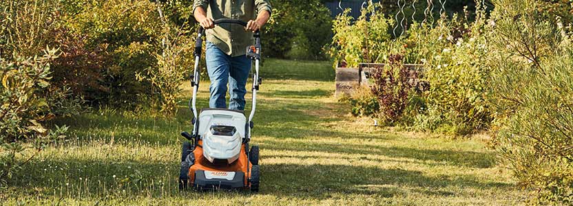 Woman doing Lawncare in autumn with a Stihl lawn mower RMA 460 side view left