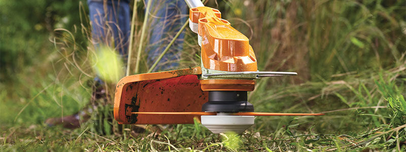 Woman thinning a overgrown garden area with a cordless STIHL brushcutter