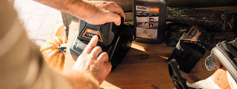 Checking the status of a battery of the STIHL AK system in the charger on a work bench