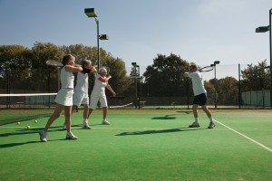 Senior and mature adults practising tennis
