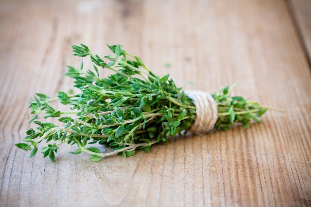 bunch of fresh organic thyme on a wooden background