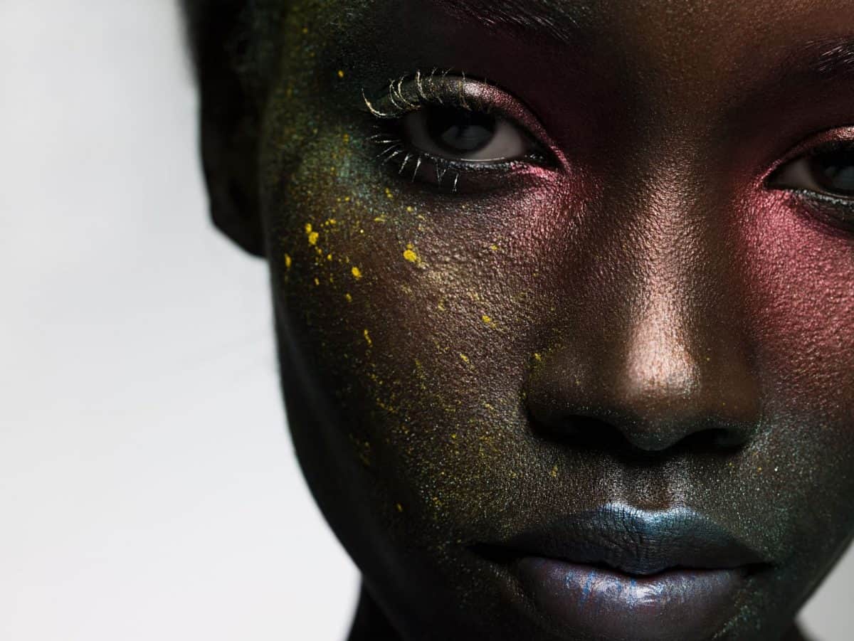 Young woman with face covered in metallic make up
