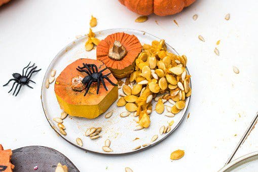 Pumpkin and spider decorations for Halloween raw pepitas, roasted pepitas, pumpkin seeds, pumpkin recipes