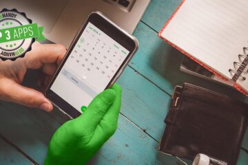 Kalender-App: Smartphone in der Hand, Tisch im Hintergrund