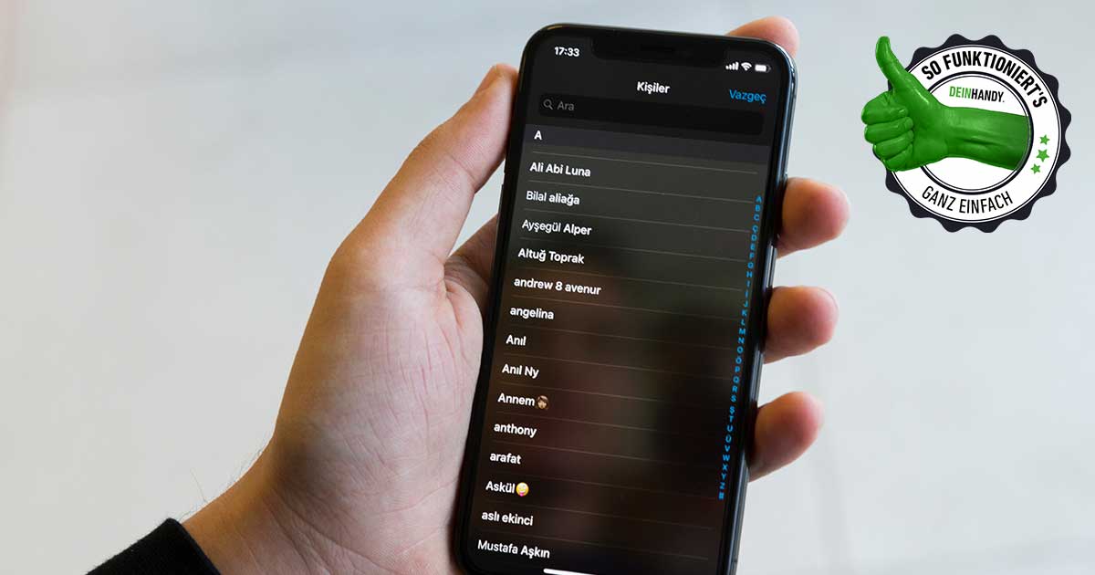iPhone Kontakte löschen: Hand mit iPhone auf dem Kontakte zu sehen sind