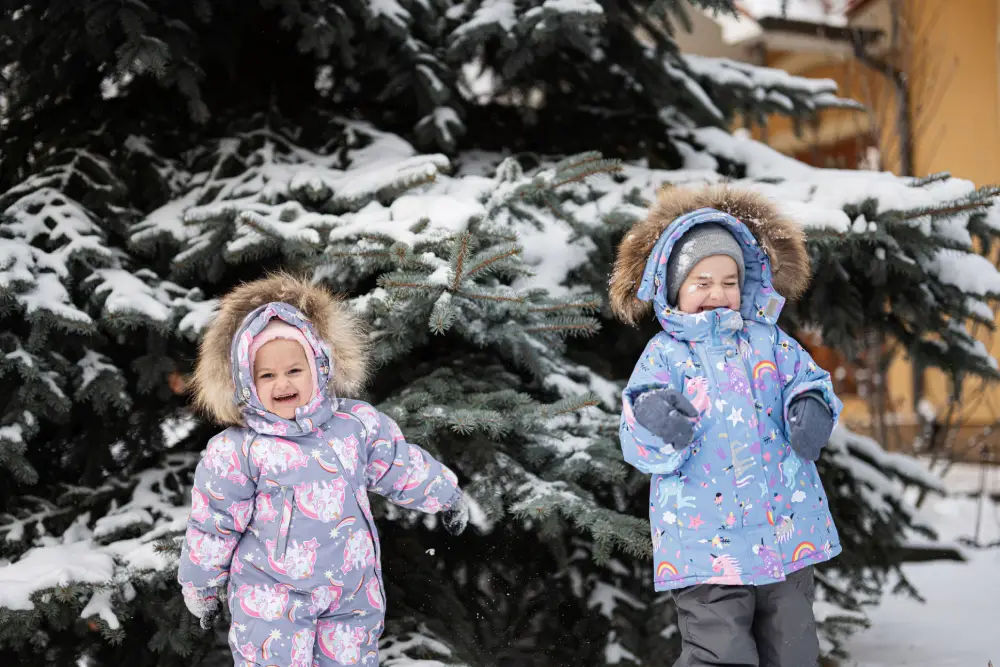 Two children playing in the snow near ski resort